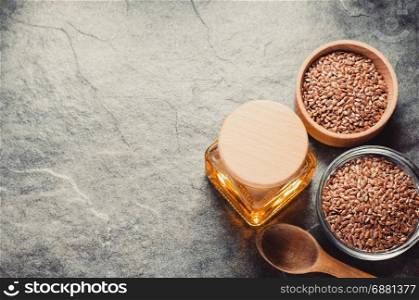 linseed oil in bottle and flax seeds on table background