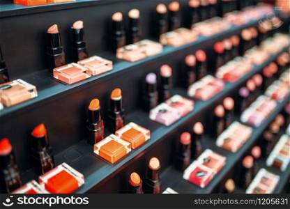 Lipstick collection in beauty shop closeup, nobody. Makeup products on showcase in store, cosmetic set