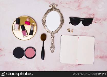 lipstick nail polish bottles compact face powder makeup brush hand mirror clutcher open blank diary pink backdrop