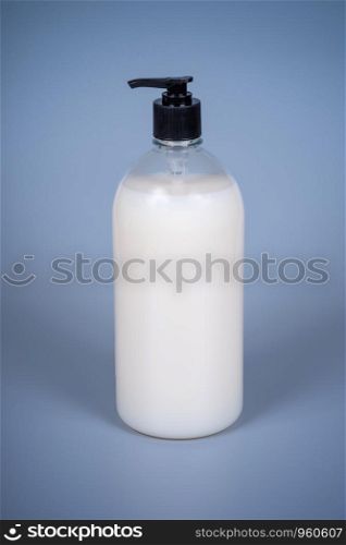 Liquid soap in a plastic bottle with a dispenser on a gray background. Liquid soap in a plastic bottle with a dispenser