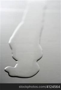 Liquid,transparent oil shape on a stainless steel metal surface