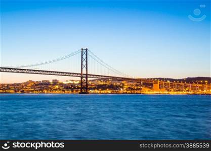Lisbon cityscape with 25 de Abril suspension Bridge, Portugal at dusk