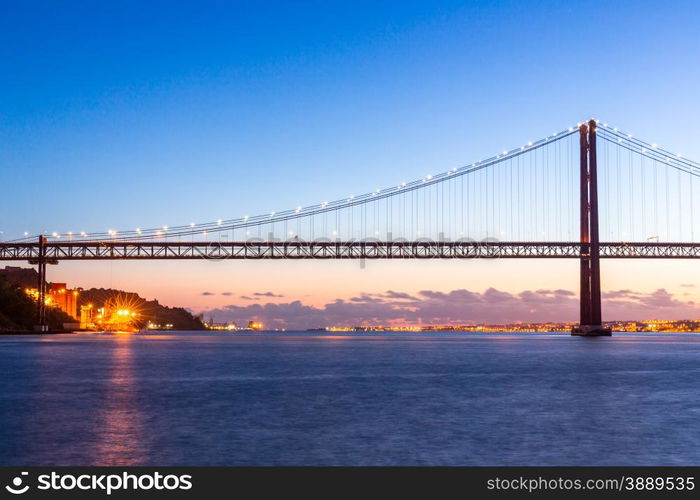 Lisbon cityscape with 25 de Abril suspension Bridge, Portugal at dusk