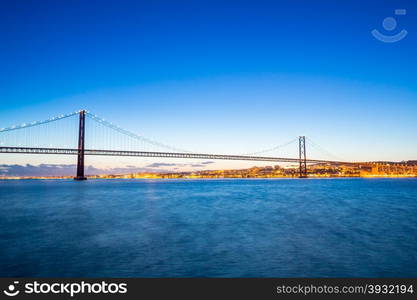 Lisbon cityscape with 25 de Abril suspension Bridge, Portugal at dusk