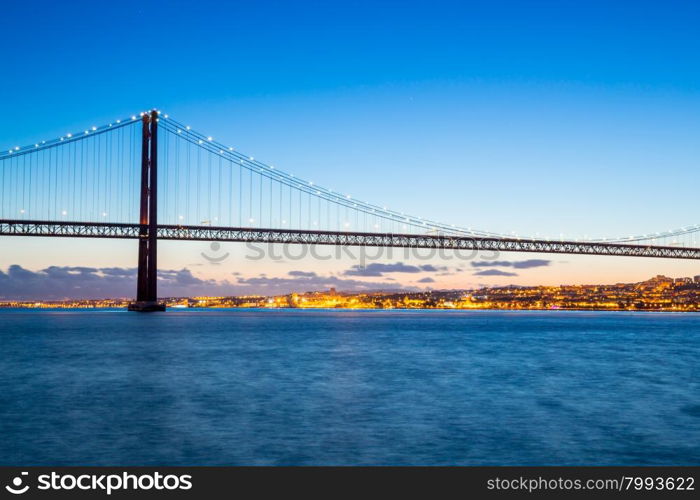 Lisbon cityscape with 25 de Abril suspension Bridge, Portugal at dusk