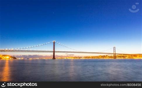 Lisbon cityscape with 25 de Abril suspension Bridge, Portugal at dusk