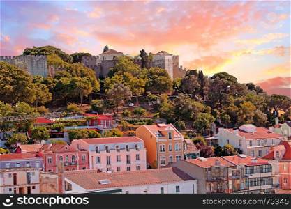 Lisbon houses with the St. Jorge castle in Lisbon Portugal at sunset