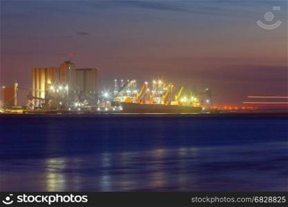 Lisbon. Sea port.. View of the dry cargo ship at the pier in the seaport of Lisbon at night. Portugal.