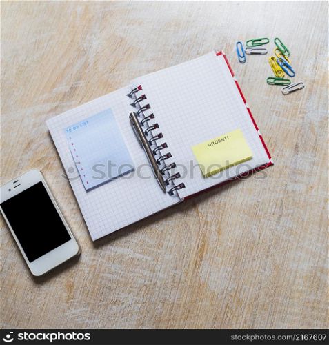 list notepad urgent sticky note checkered notebook with smartphone paperclip