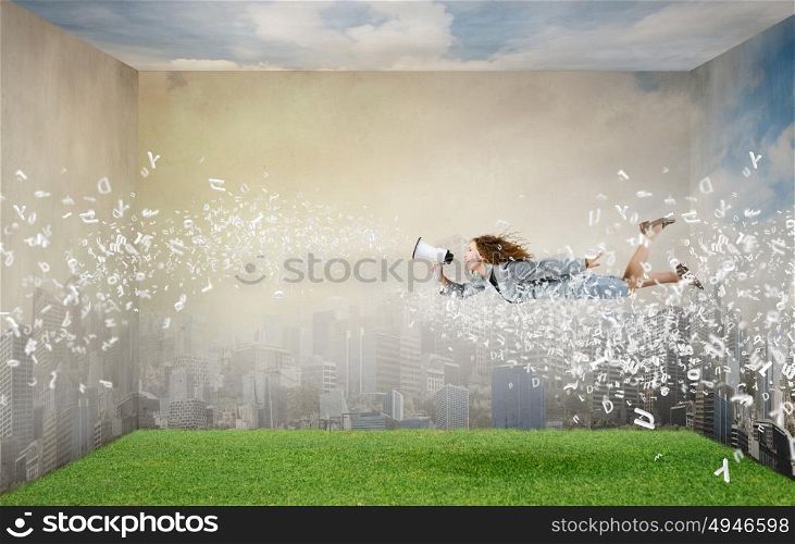 Listen everybody!. Young woman with megaphone flying in sky and announcing something