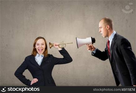 Listen everyone. Young aggressive businessman in suit proclaiming something in horn