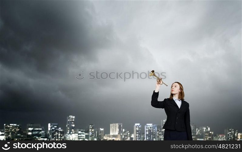Listen everyone. Young businesswoman in suit proclaiming something in horn