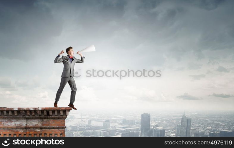 Listen everyone. Young man making some announcement in trumpet