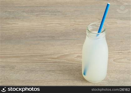 Litchi juice in a glass bottle with a blue straw