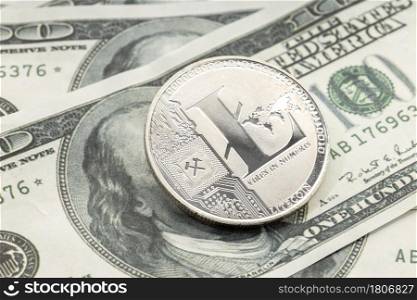Litecoin coin on dollar banknotes. Cryptocurrency on US dollar bills