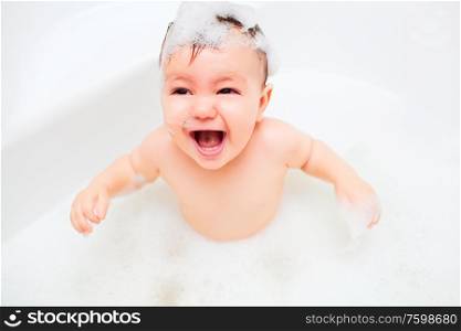 litlle child bathes in a bathroom