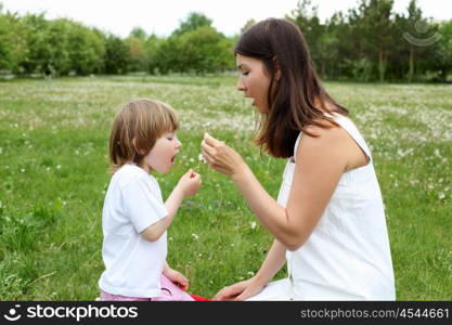 litlle girl with her mother outdoors on the grass