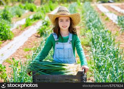 Litte kid farmer girl in onion harvest at orchard