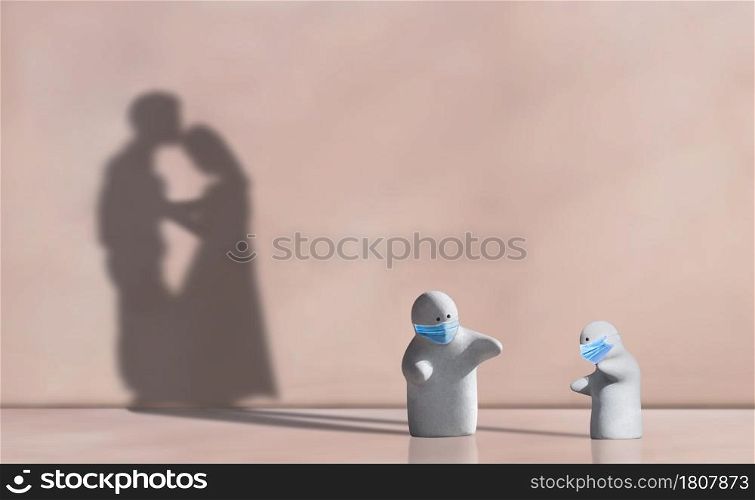 Little 2 garden dolls wearing protective mask in distancing concern gesture with shadow of couple contiguous encouraging on pink wall background, Metaphorical concept of adaptive lifestyle in COVID-19
