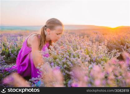 Little adorable girl in lavender flowers field at sunset in purple dress. Woman in lavender flowers field at sunset in white dress and hat