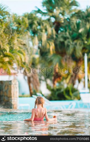 Little adorable girl in outdoor swimming pool in luxuxry resort. Little adorable girl in outdoor swimming pool