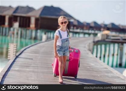 Little adorable girl with big luggage background of water villa. Little adorable girl with big luggage during summer vacation