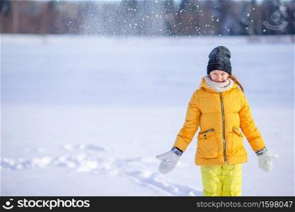 Little adorable happy girl in the snow winter day outdoors. Portrait of little adorable girl in snow sunny winter day
