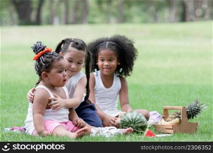 Little African and Caucasian kids picnic and playing in the park. Little cute girl hugging and consoling her crying friend. Friendship of diverse ethnicity children
