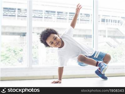 Little african cute and naughty boy playing and dancing on the floor in living room at home. Education Concept.