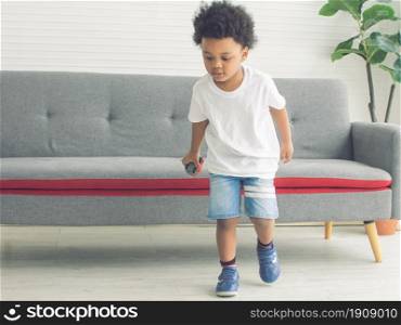 Little african cute and naughty boy playing in living room at home. Education Concept.