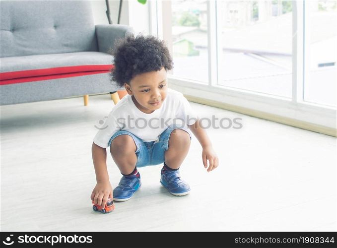Little african cute and naughty boy playing on the floor in living room at home. Education Concept.