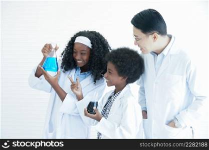 Little African kids studying chemistry and doing chemical science experiment in laboratory at school with Asian teacher man. Excited dark skinned boy and girl looking at liquid color in test bottle