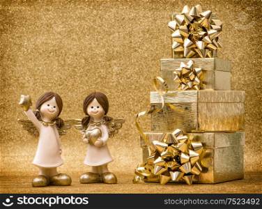 Little angels with gifts. Ribbon bow on golden shiny background. Holidays decoration. Vintage style toned picture vignette