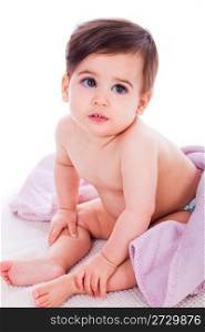 Little baby bending down and covered with purple towel in a white isolated background