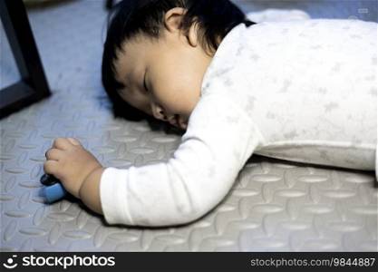 Little baby boy lying on the floor. Boy Sleeping On Floor With Car Toy In His Hand