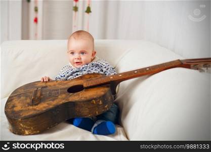 Little baby boy with an old vintage guitar