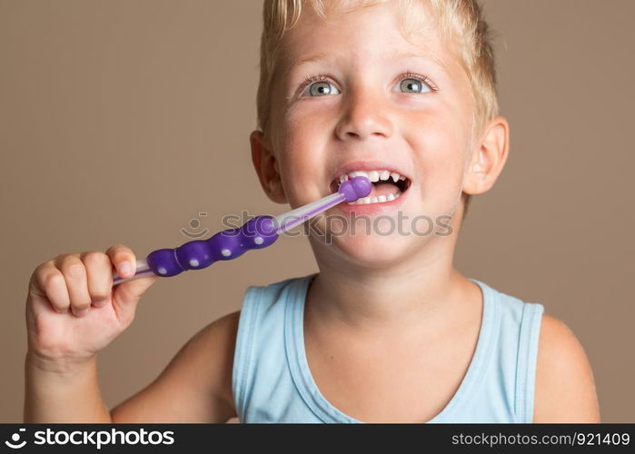 little baby boy with tooth brush,dental hygiene and health for children,brown background.