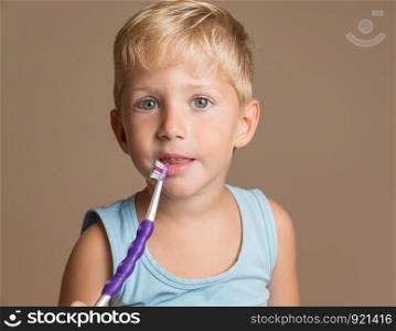 little baby boy with tooth brush,dental hygiene and health for children,brown background.
