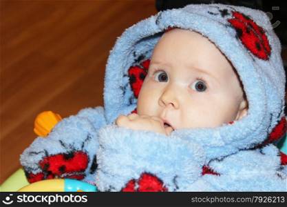 little baby in blue dressing gown with amazed sight