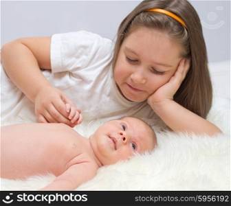 Little baby with sister on bed
