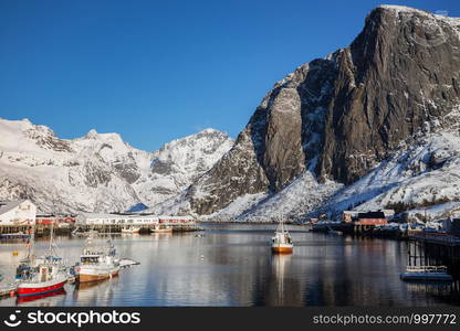 Little bay in winter on Lofoten islands. ships and rorbu in the rays of dawn. Norway