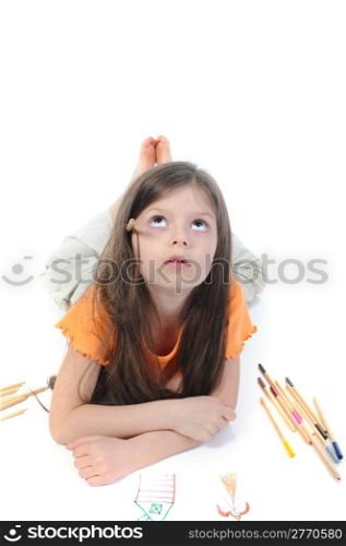 Little beautiful girl draws pencil lying on the floor. Isolated on white background