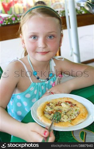 little beautiful girl eating pizza in cafe. girl eating pizza