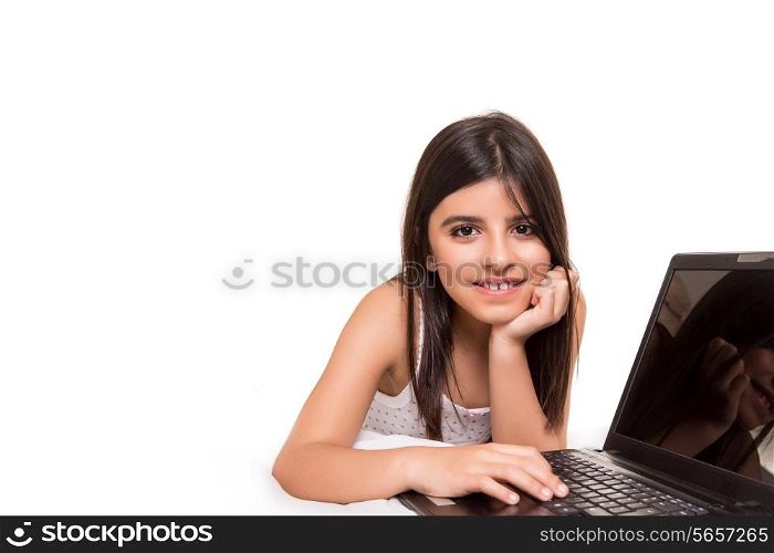 Little beautiful girl with a laptop on bed