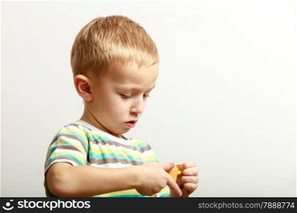 Little blond boy child kid preschooler playing with colorful building blocks toys interior. At home. Childhood and development.
