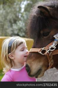 little blond girl loves her pony funny portrait