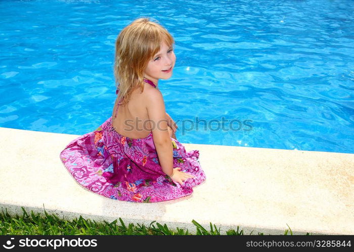 Little blond girl sitting smiling swimming pool outdoor