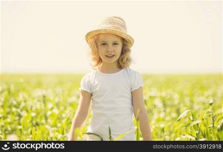 Little blonde girl in a wheat field, summer outdoor