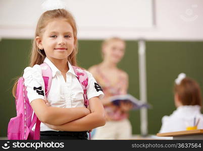 Little blonde girl studying at school class