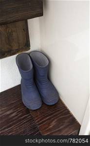 little blue rain boots in the closet, for children close-up. little blue rain boots in the closet, for children